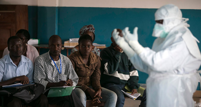 A health worker demonstrates putting on protective gear in a Red Cross facility in the town of Koidu, Kono district in Eastern Sierra Leone December 18, 2014.Sierra Leone, neighbouring Guinea and Liberia are at the heart of the world's worst recorded outbreak of Ebola. Rates of infection are rising fastest in Sierra Leone, which now accounts for more than half of the 18,603 confirmed cases of the virus. 