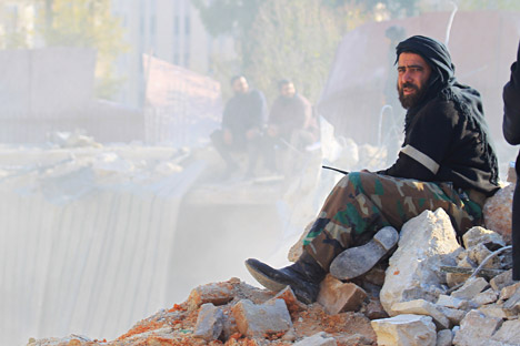 A member of a local security force, in charge of policing the area sits on rubble while he oversees the search for survivors at a site hit yesterday by what activists said were airstrikes carried out by the Russian air force in Idlib city, Syria, Dec. 21, 2015
