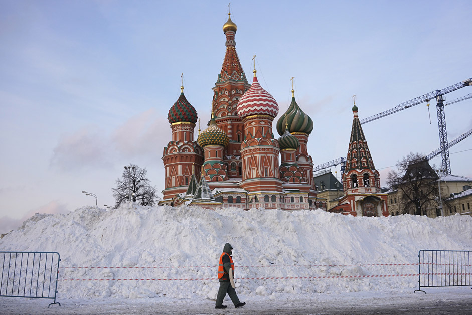 Ein Straßenfeger geht an der Basilius-Kathedrale am Roten Platz in Moskau vorbei.
