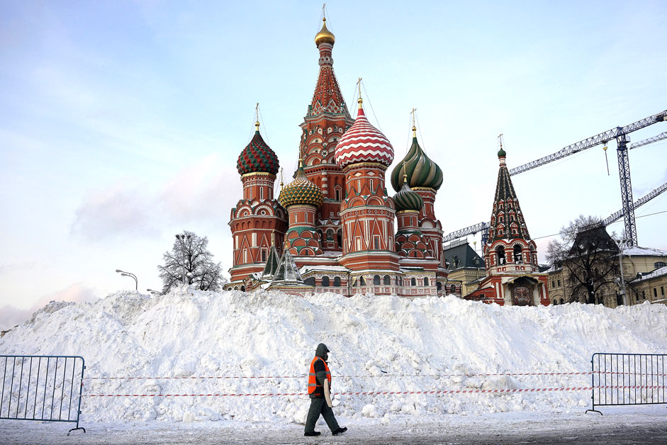 A street sweeper walks past St. Basil's Cathedral at Red Square in Moscow, Russia