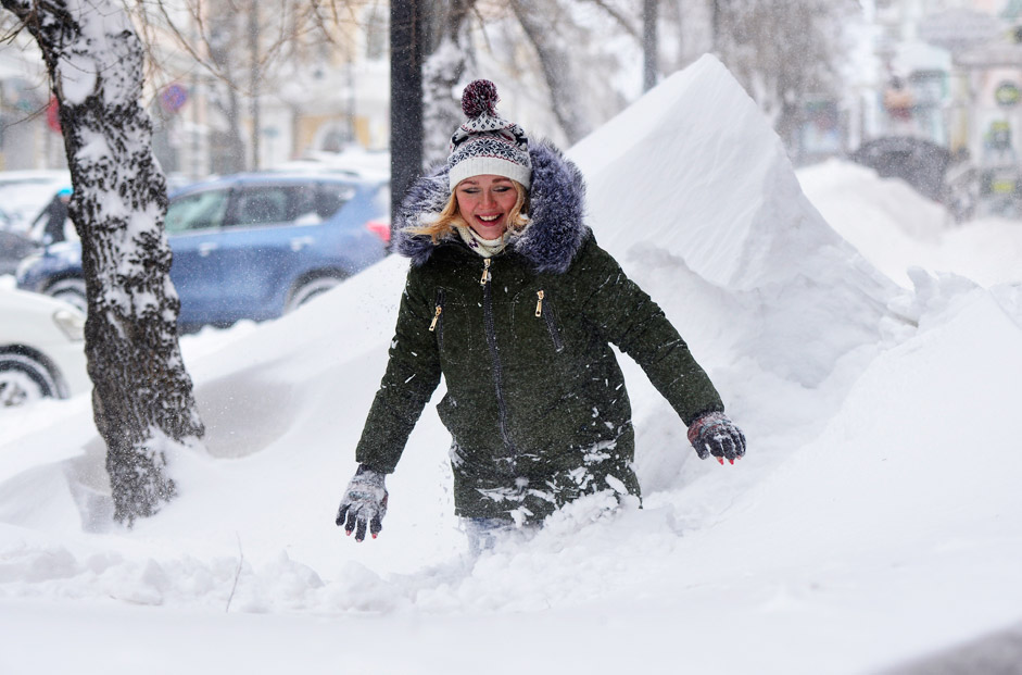 Eine Frau in Wladiwostok kämpft sich durch die Schneemassen. Nach einem Schneesturm sind sie teils mannshoch.