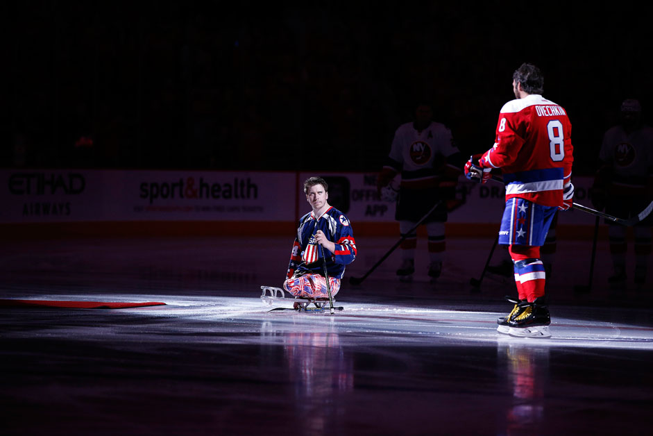 US Marine Corps Lance Corporal Joshua Misiewicz, a member of the USA National sled hockey team, waits for Washington Capitals left wing Alex Ovechkin (8), from Russia, for a pre-game ceremonial puck drop before an NHL hockey game against the New York Islanders