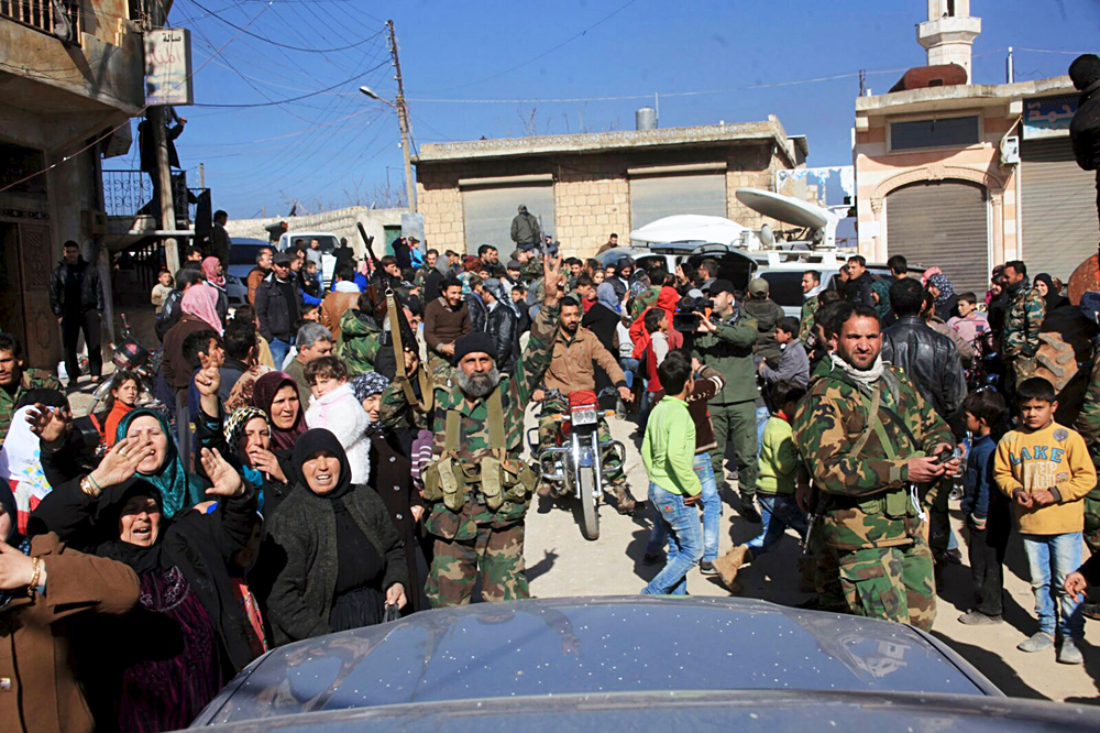 Residents of Nubul and al-Zahraa, along with forces loyal to Syria's President Bashar al-Assad, celebrate after the siege of their towns was broken, northern Aleppo countryside, Syria, in this handout picture provided by SANA on Feb.y 4, 2016. 