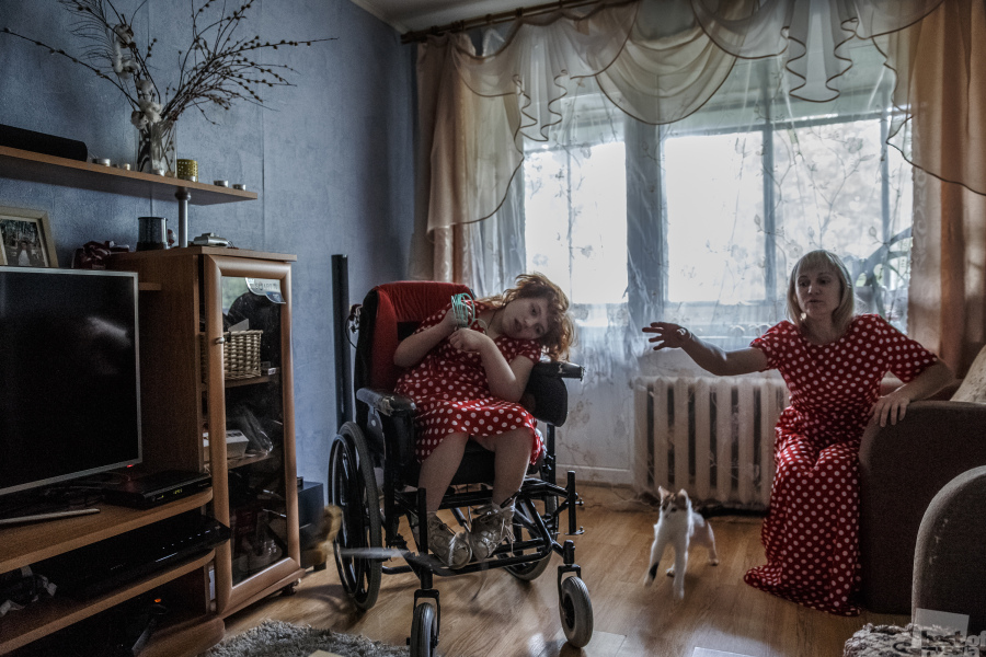 A photo from a series about unwed mothers bringing up disabled children. Karina age 16 with her mother.