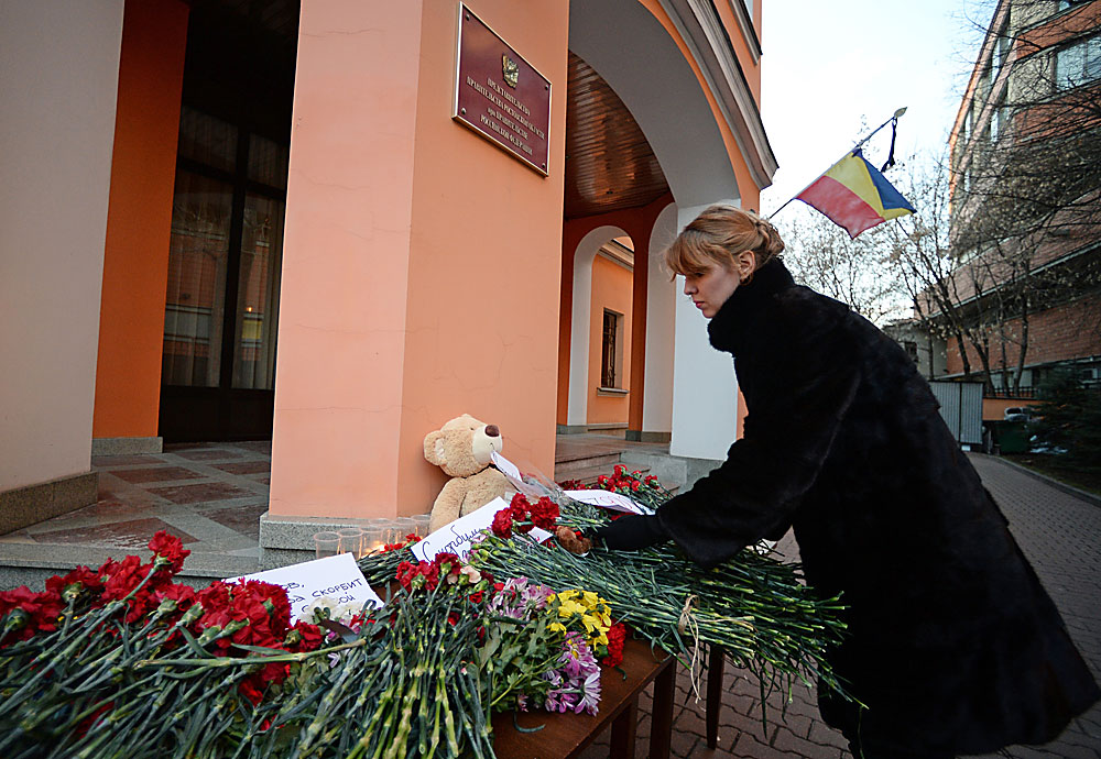 A woman lays flowers in memory of the Boeing 737-800 crash victims in Rostov-on-Don laid outside the Rostov Region delegation office in Moscow. landscape, airplane, flowers, scorn, grief, air crash, flight. tragedy, flight, rostov, boeing, mscow mourns with you, fz981