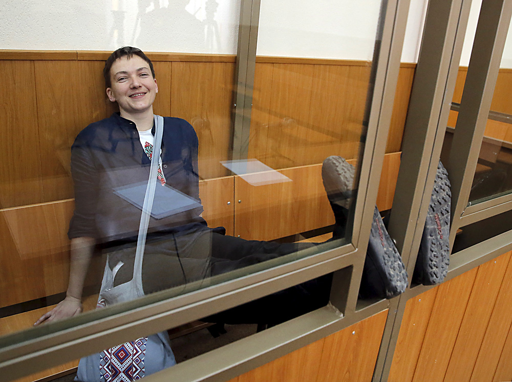 Piloto ucraniana ri enquanto aguarda veredito em cela de vidro no tribunal.