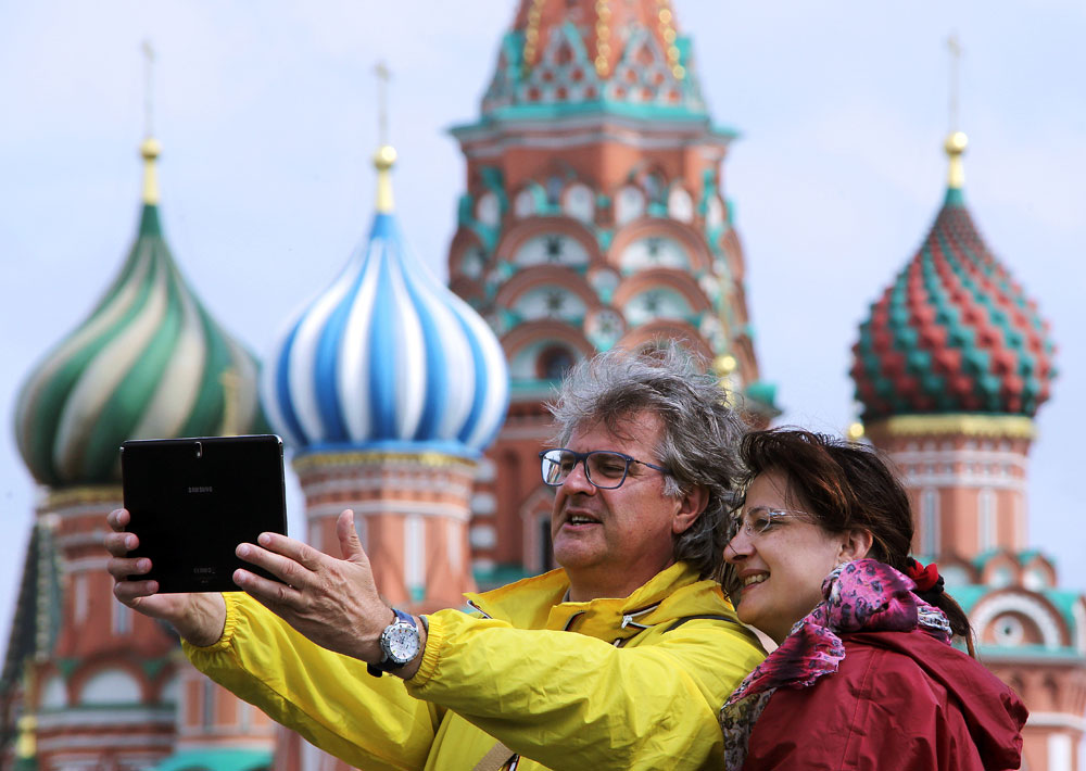 Wisatawan asing tampak tengah berfoto di dekat Katedral St. Basil di Lapangan Merah, Moskow, Rusia.
