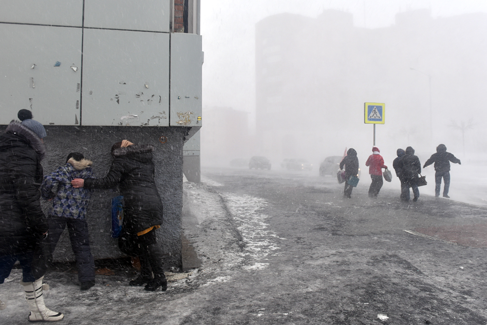 Россия. Норильск. 23 марта 2016. Жители города во время урагана. 