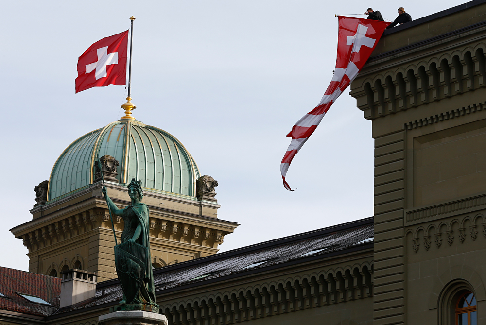 Installation d'un drapeau suisse sur l'Assemblée fédérale (parlement) suisse à Berne le 24 novembre 2015.