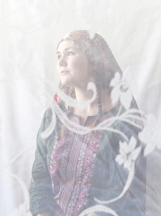 Photographed through lace curtains, like through a bridal veil, women are visible through the screen of another cultural tradition. In the photos, these women are depicted as a "Tatar Madonna." / Oxana, 23, art school teacher. “My grandmother was Tatar. I always regard myself as Russian, but I often was called ‘Eastern’. My natural hair color is light brown, but I often dyed it black. Probably subconsciously I was highlighting my ‘Eastern’ roots”.