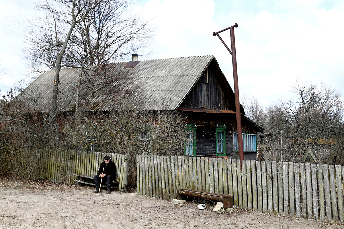 Ivan Shamyanok sits in front of his house in the village of Tulgovichi, near the exclusion zone.