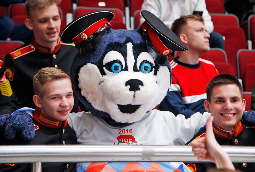 A mascot of Championships Laika sits among cadets during the Hockey World Championships Group B match between France and Belarus in St.Petersburg, Russia