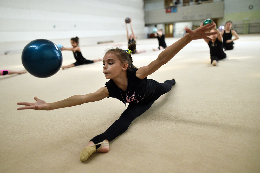 Млади гимнастички тренират с топки в едно от спортните училища в Москва.
