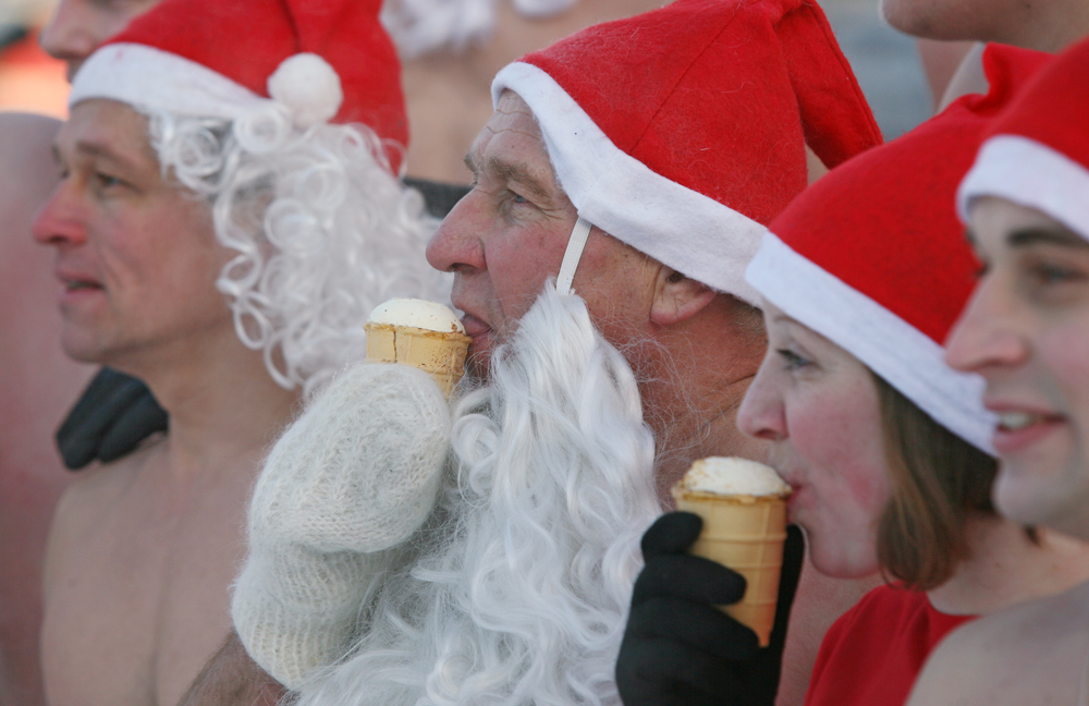 Anggota klub pelatihan musim dingin Spektr dan federasi renang musim dingin Polar Dolphins, berpakaian seperti Ded Moroz (Kakek Beku, Sinterklasnya Rusia), makan es krim saat balapan tahun baru mereka di Novosibirsk, Rusia.