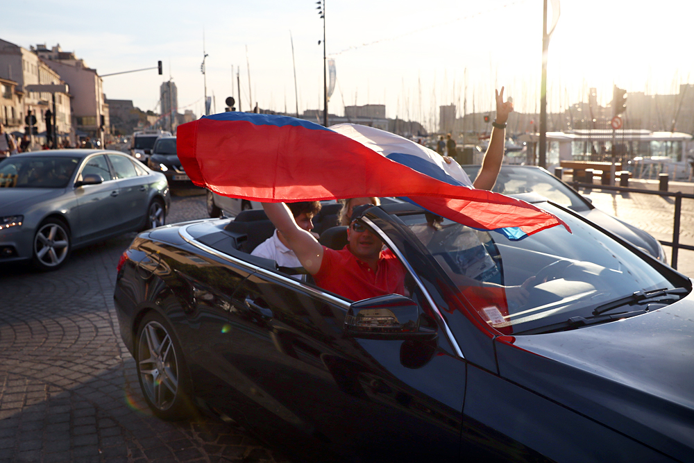 MARSEILLE, FRANCE - JUNE 09: Russian football fans hold a flag as they drive in Marseille ahead of the England v Russia game on Saturday, on June 9, 2016 in Marseille, France. Football fans from around Europe have descended on France for the UEFA Euro 2016 football tournament.