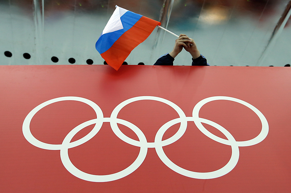 La bandiera russa sventola sopra i cinque anelli olimpici.