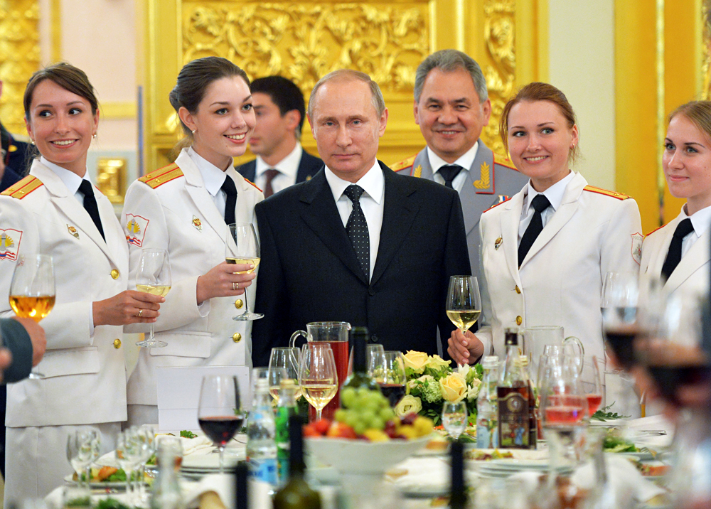 Russian President Vladimir Putin (C) and Defence Minister Sergei Shoigu (back) attend a reception to honour graduates of military academies at the Kremlin in Moscow, Russia, June 28, 2016. 