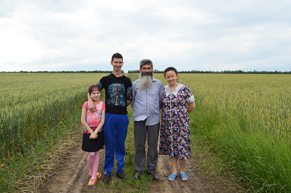 The Konovalovs, a family of Molokans, stand among their fields. Their ancestors fled from Turkey to Russia in the middle of the last century.