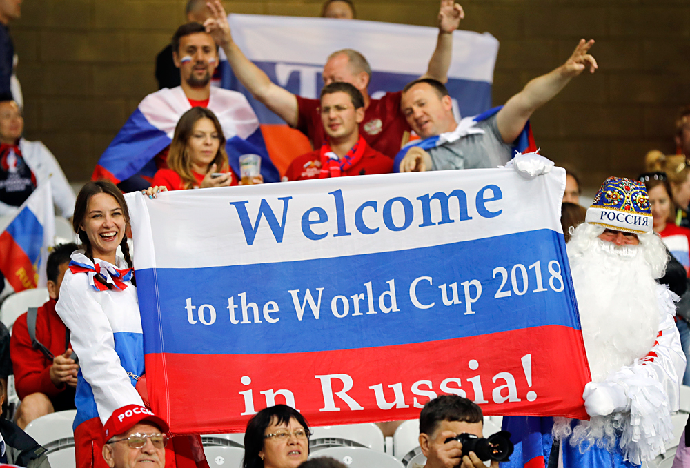 Beberapa orang pendukung timnas Rusia memegang bendera Rusia dengan tulisan "Selamat datang di Piala Dunia 2018 di Rusia", ketika sedang menunggu dimulainya pertandingan Grup B Piala Eropa 2016 antara Rusia melawan Slovakia di Stadion Pierre Mauroy di Villeneuve d'Ascq, dekat Lille, Prancis, 15 Juni 2016.