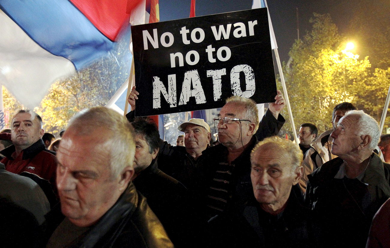 Seorang demonstran memegang papan protes dalam demonstrasi anti-NATO di Podgorica, Montenegro.