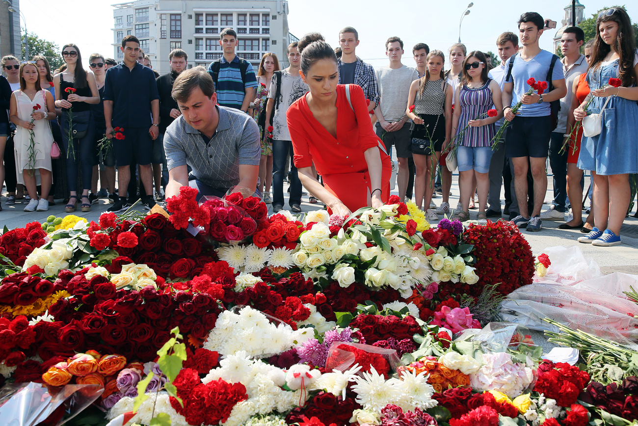 People lay flowers at the French Embassy in Moscow commemorating the victims of the 2016 terror attack in the French resort city of Nice