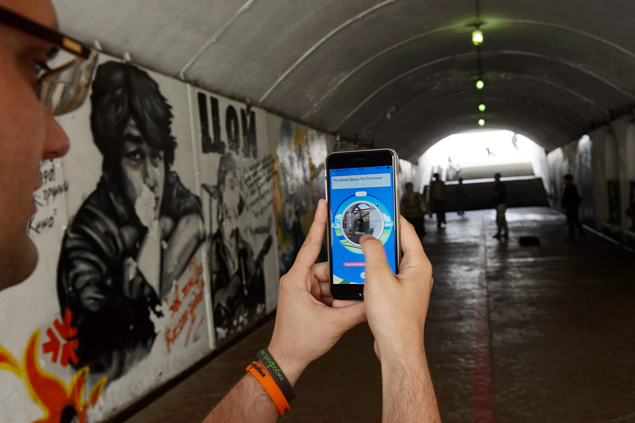 Jugador de Pokémon GO en la ciudad siberiana de Ekaterimburgo pasa junto a un mural dedicado al rockero Víktor Tsoi.
