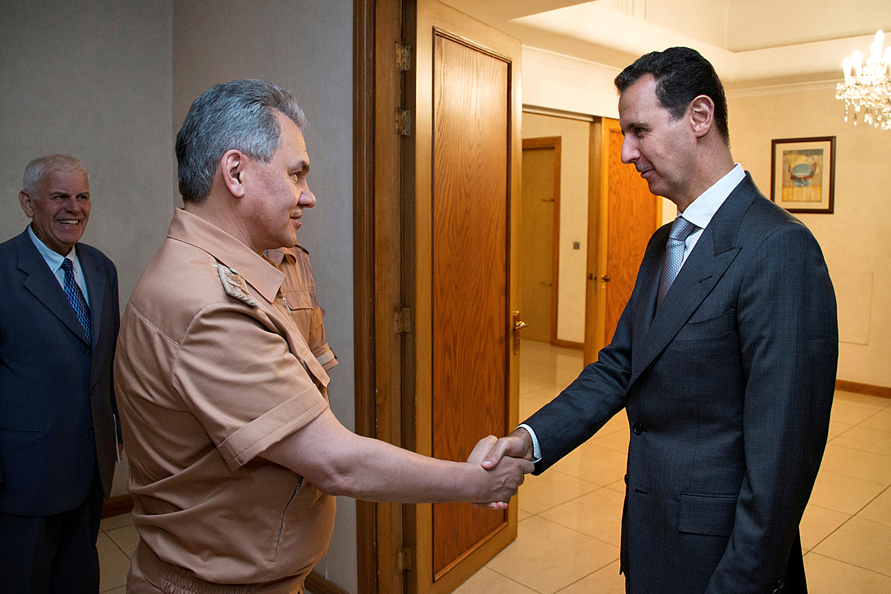 Sirski predsednik Bašar al-Asad se v Damasku rokuje z ruskim obrambnim ministrom Sergejem Šojgujem. Sirija, 18. junija 2016.