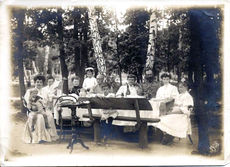 Dacha consisted of an old wooden house with a terrace, a butler, postprandial promenades, family concerts, and readings in the evening. / Drinking tea at the dacha, 1908.