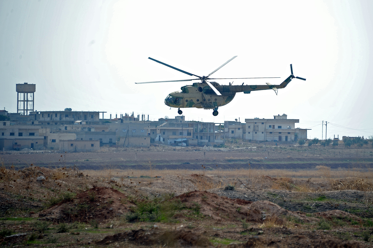 Sebuah helikopter Mi-8 terbang di atas Pangkalan Udara Hama di dekat kota Hama, Provinsi Hama, Suriah.