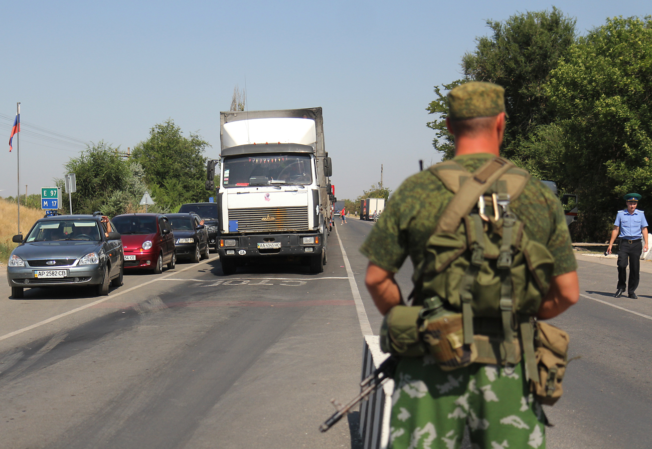 Kendaraan-kendaraan mengantre pada pos pemeriksaan "Armyansk", di perbatasan Ukraina-Rusia.