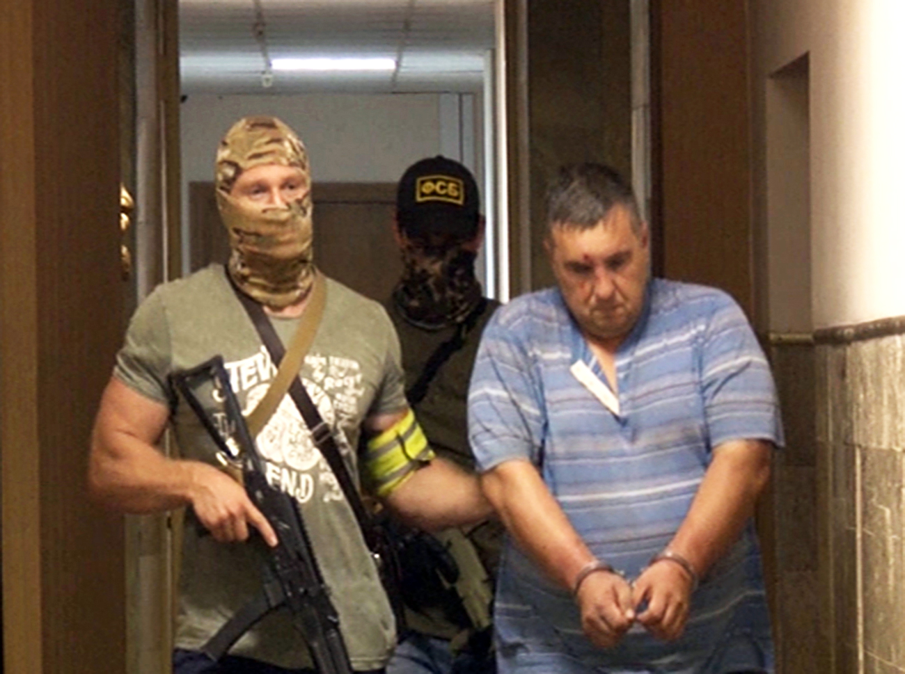 Вдясно: украински диверсант, задържан от руската Федерална служба за сигурност в Крим. Задържаното лице е планирало да извърши поредица от нападения с експлозиви в Крим. (кадър от клип, предоставен от прес центъра на ФСБ)