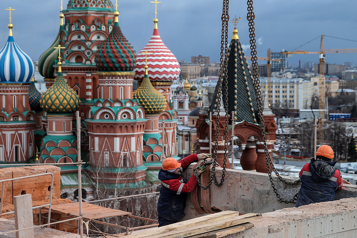 Des ouvriers aperçus entre la Tour Spasskaya et le Bâtiment du Sénat du Kremlin de Moscou (sur l’image).