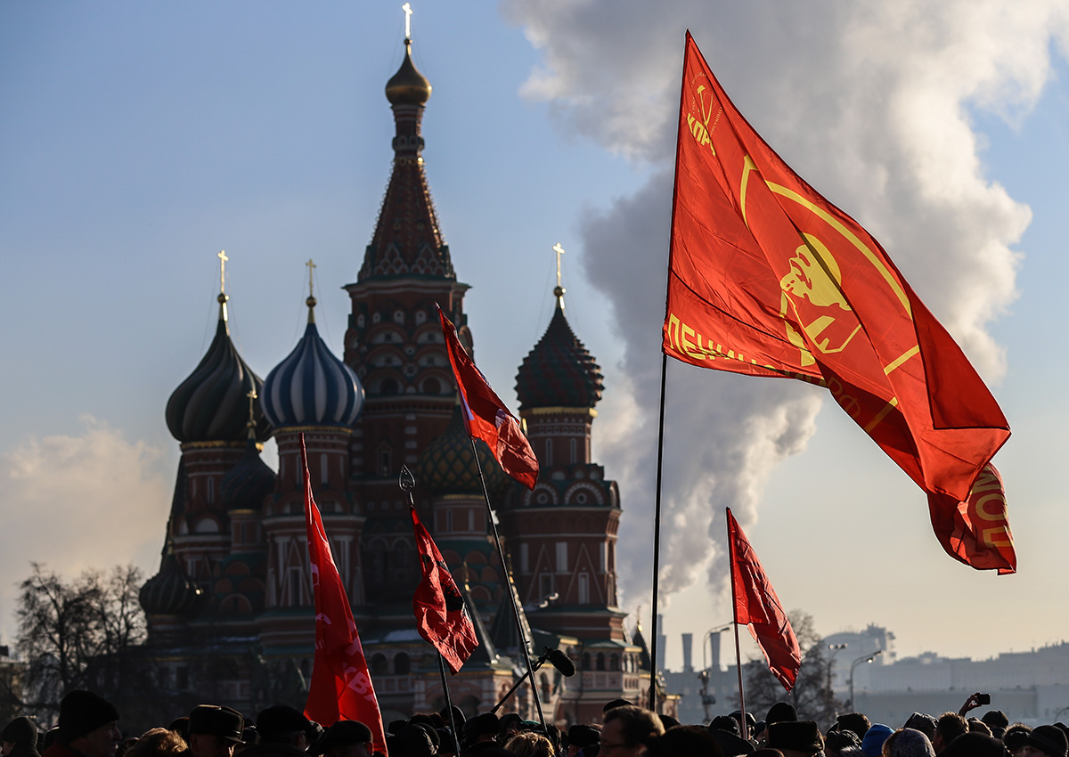 Ljudje z rdečimi komunističnimi zastavami čakajo v vrsti, da položijo rože k Leninovemu mavzoleju. Dogodek, s katerim so obeležili 91. obletnico Leninove smrti, je 21. januarja 2015 organizirala Komunistična partija Ruske federacije.