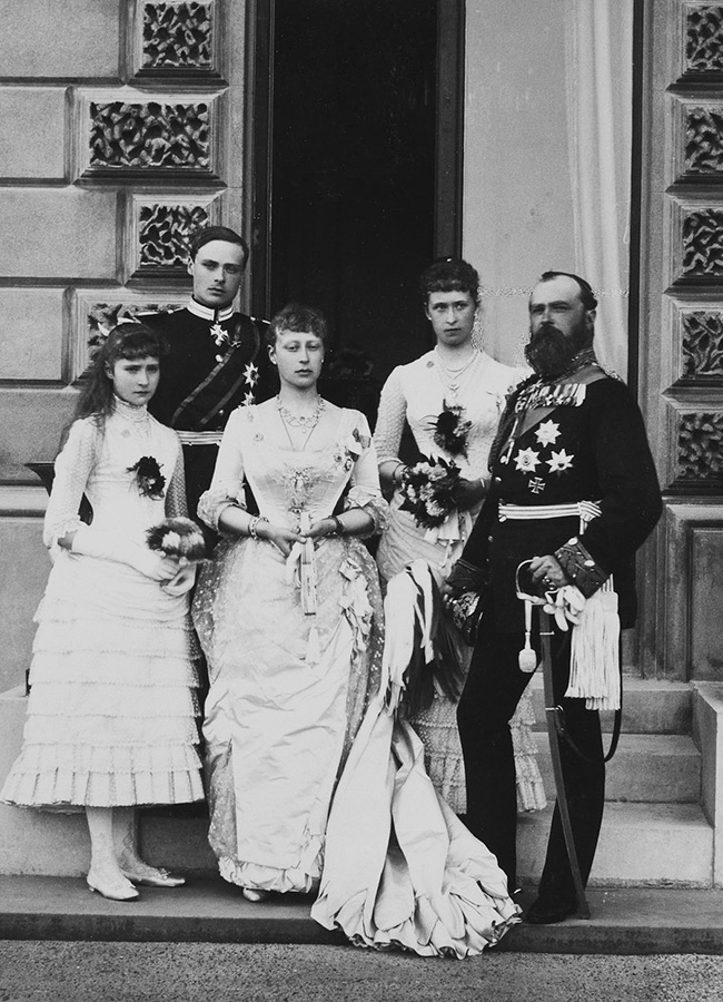　後にアレクサンドラ・フョードロヴナとなるヘッセン家出身のアリックスがロシアを初めて訪問したのは、姉のエラがニコライの叔父であるセルゲイ・アレクサンドロヴィチと結婚した際のことで、アリックスが12歳の時だった。 皇太子だったニコライは16歳で、彼はすぐに恋に落ちた。 / 娘たちとバッテンベルク侯爵に囲まれるヘッセン大公ルートヴィヒ4世。 アリックス・フォン・ヘッセンは左側に立っている。