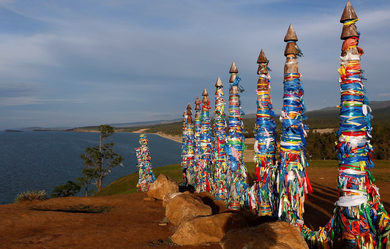 Poles with attached ritual ribbons are seen near the village of Khuzhir on the Olkhon Island on a bank of the Baikal Lake, Eastern Siberia, Russia