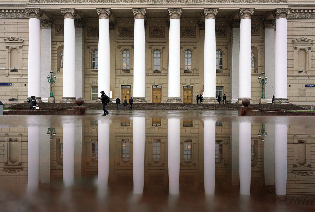 People walk near the Bolshoi Theatre in central Moscow, Russia