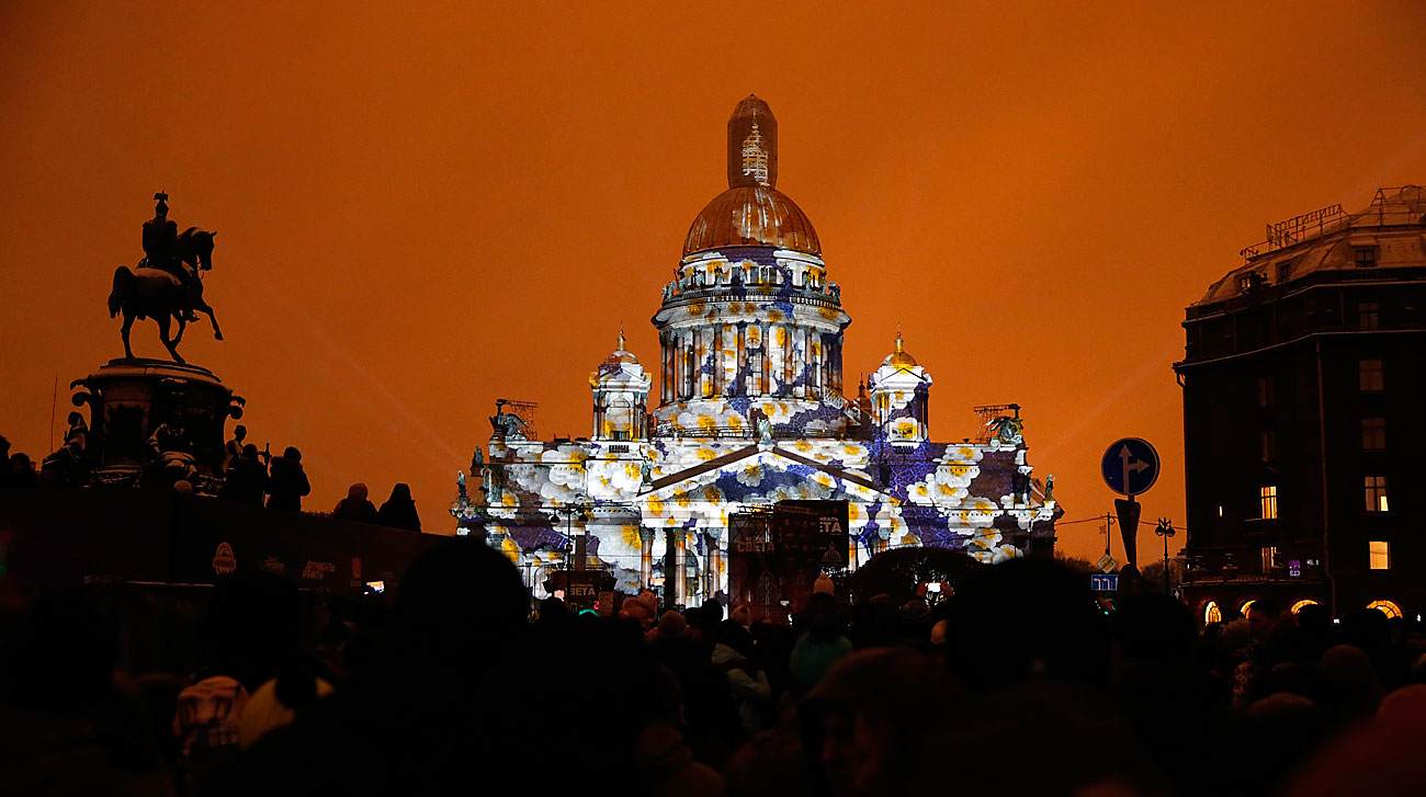 Поглед на споменикот на Николај I и осветлениот соборен храм „Св. Исак“ во текот на светлосно шоу во центарот на Санкт Петербург, Русија.