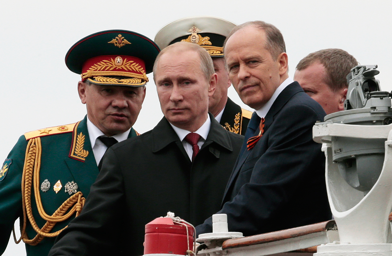 Владимир Путин, министърът на отбраната Сергей Шойгу (отляво) и директорът на ФСБ Александър Бортников. 9 май 2014 г.