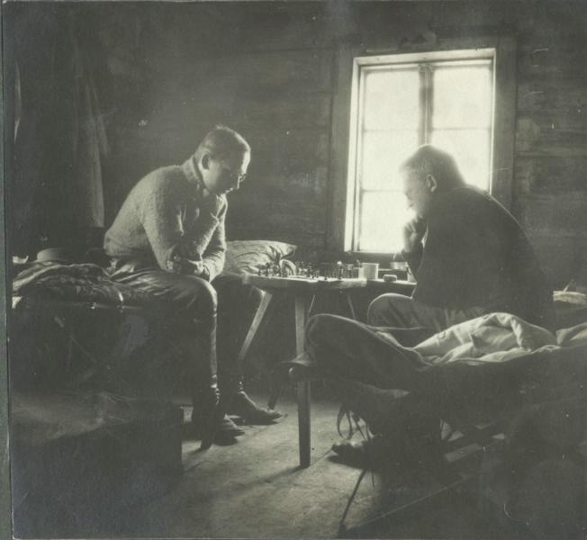 1914-1918 г. Двама мъже играят шах в дървена къща в провинцията.