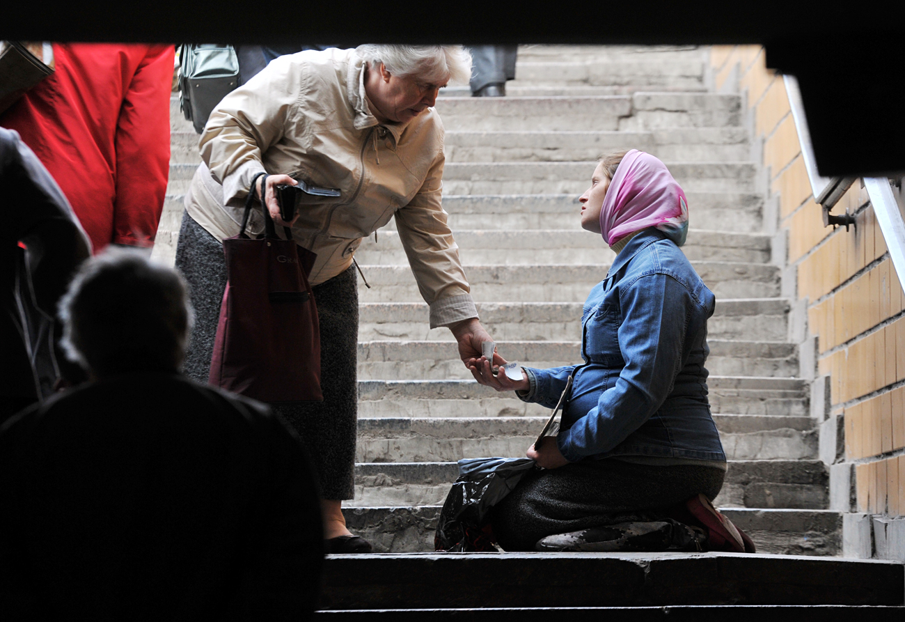 Mujer pidiendo limosna cerca de la entrada de una estación del metro de Moscú.
