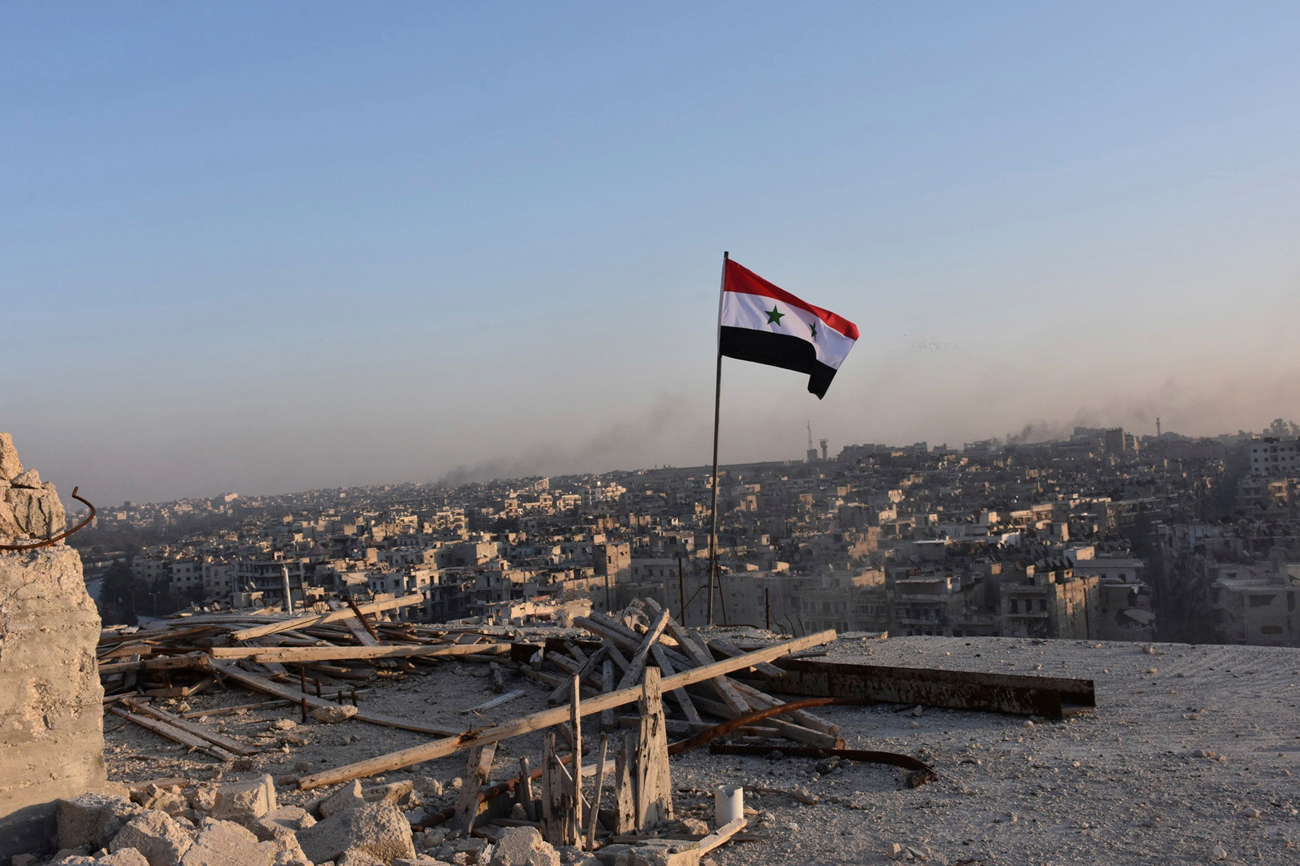 Sirska zastava nad vzhodnim Alepom po osvojitvi četrti Al-Sahour s strani sirske vladne vojske. Vir: Reuters