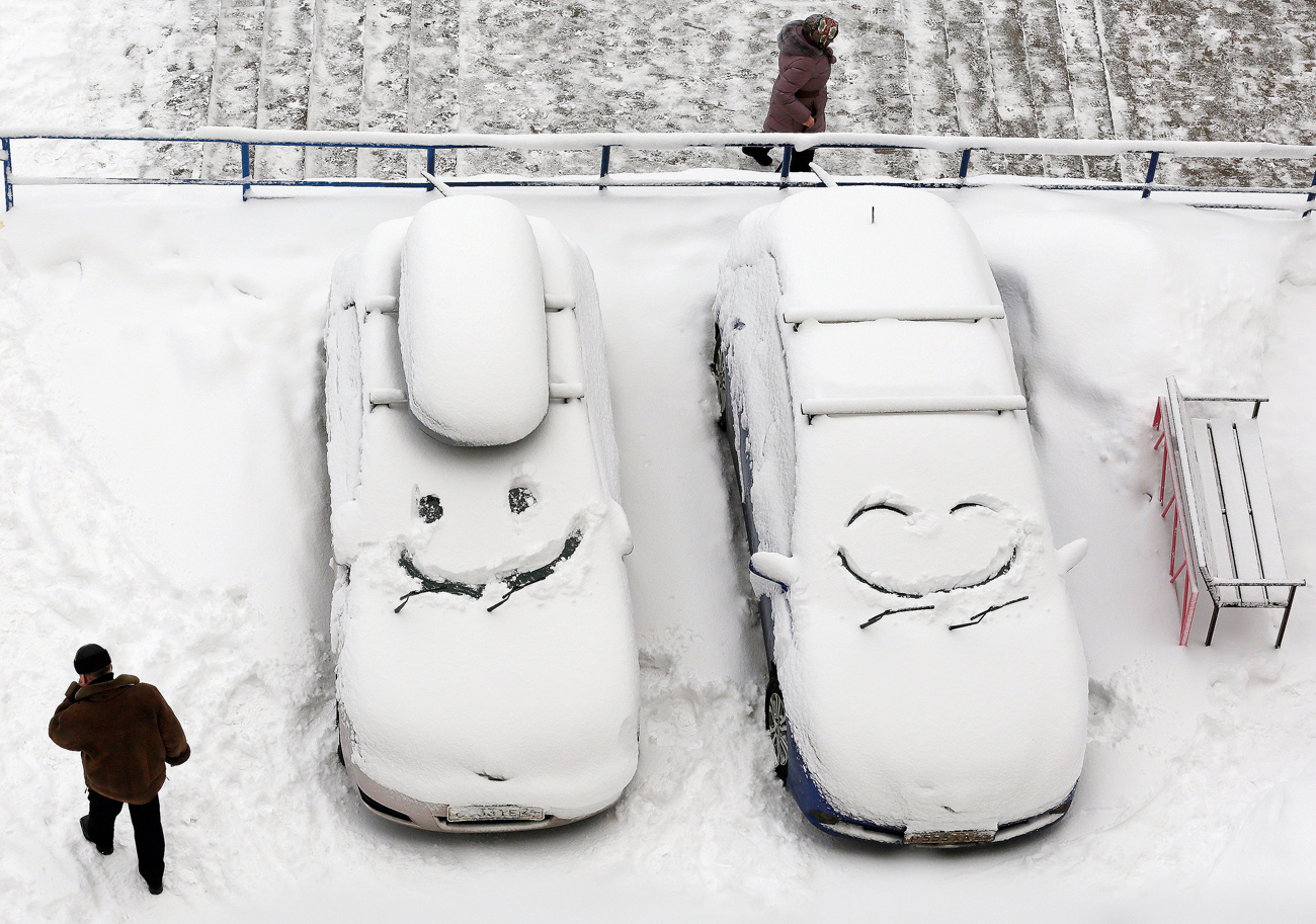 Vehículos cubiertos de nieve tras una tormenta de nieve en Krasnoyarsk, Siberia.
