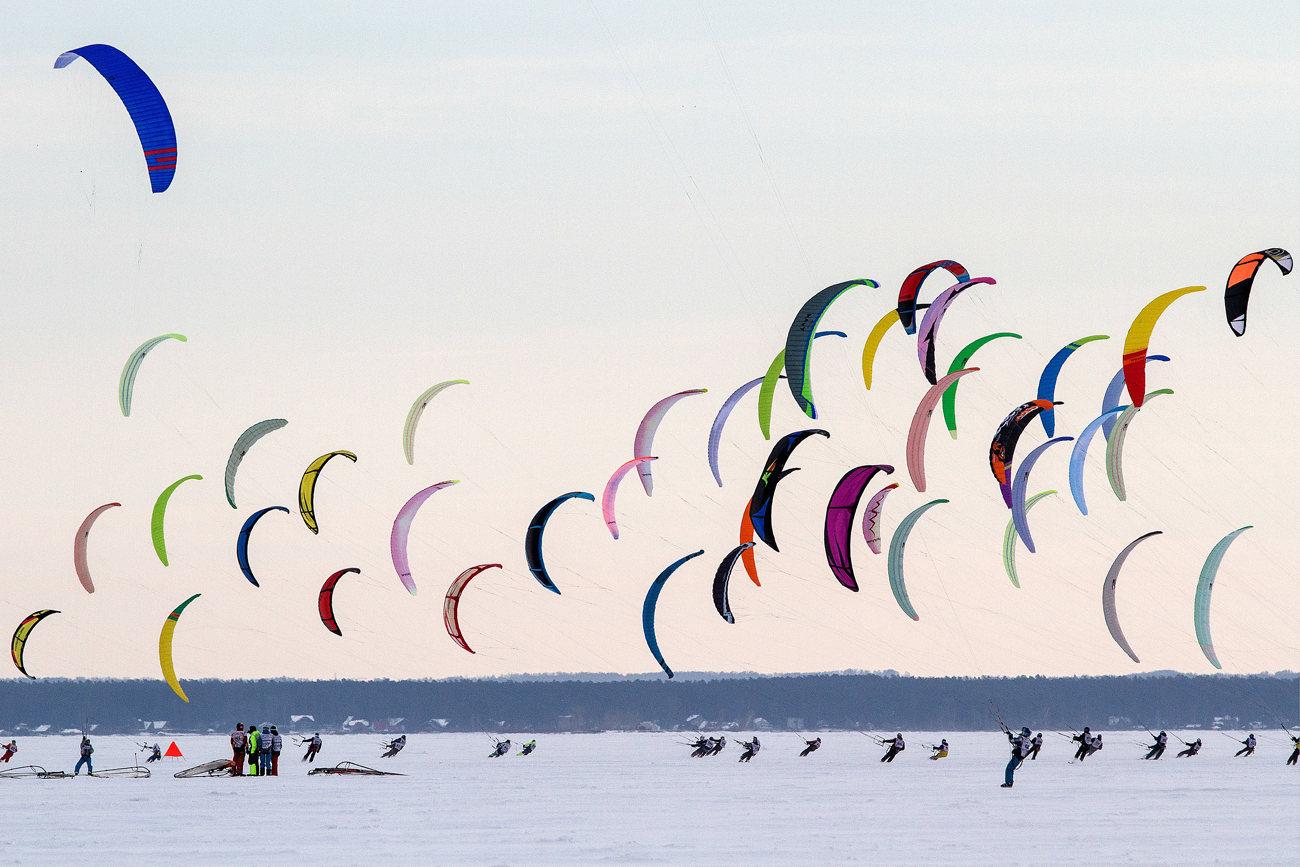 The participants of the Cup of Siberia in winter kiting - 2016 during the competition in the discipline of the course-flight on the ice reservoir of the Novosibirsk HPP