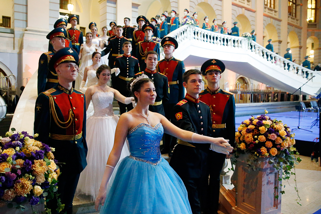 Cadetes en uniforme y jóvenes vestidas de traje participan en el baile de cadetes celebrado en Moscú.