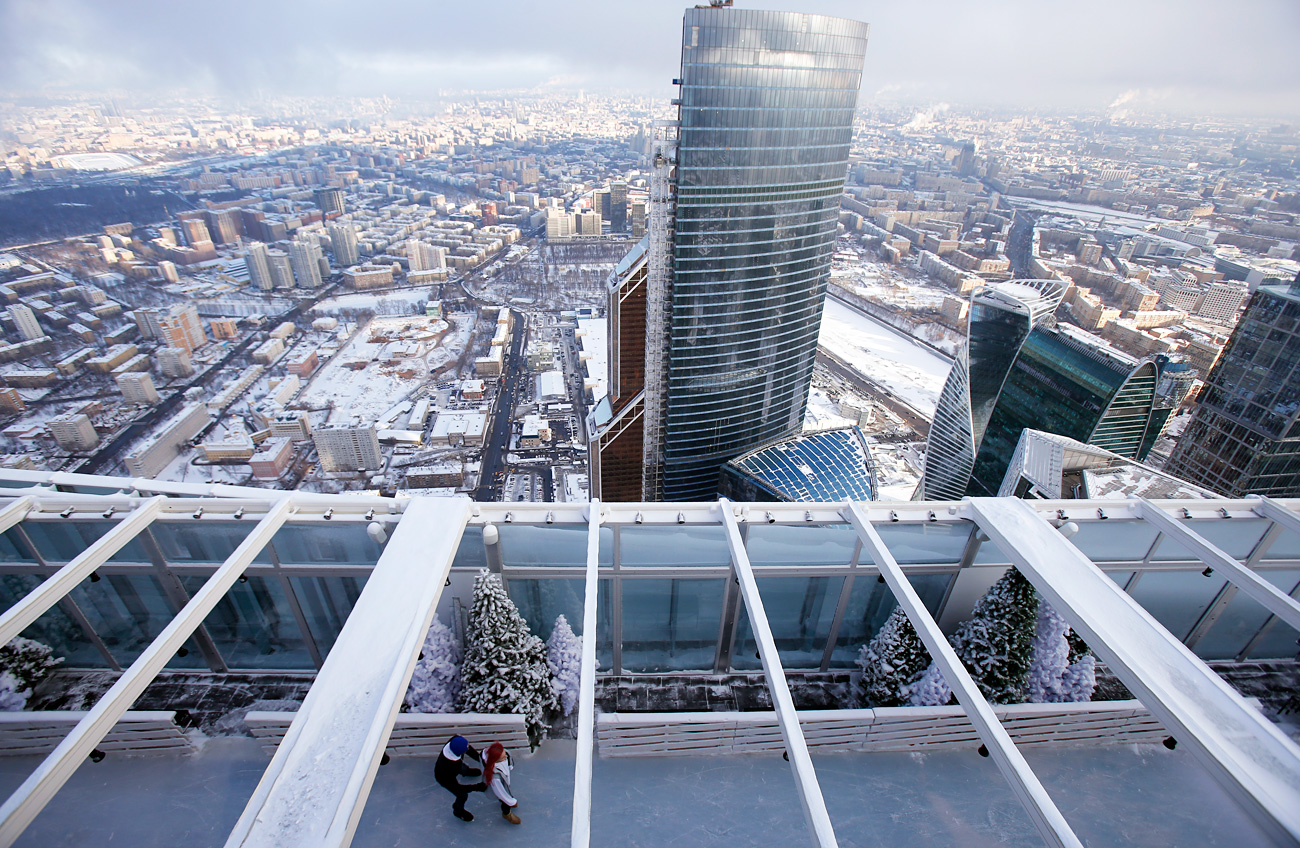 Personas patinando en la pista de hielo en el tejado del rascacielos OKO, en el centro de negocios Moscow City.