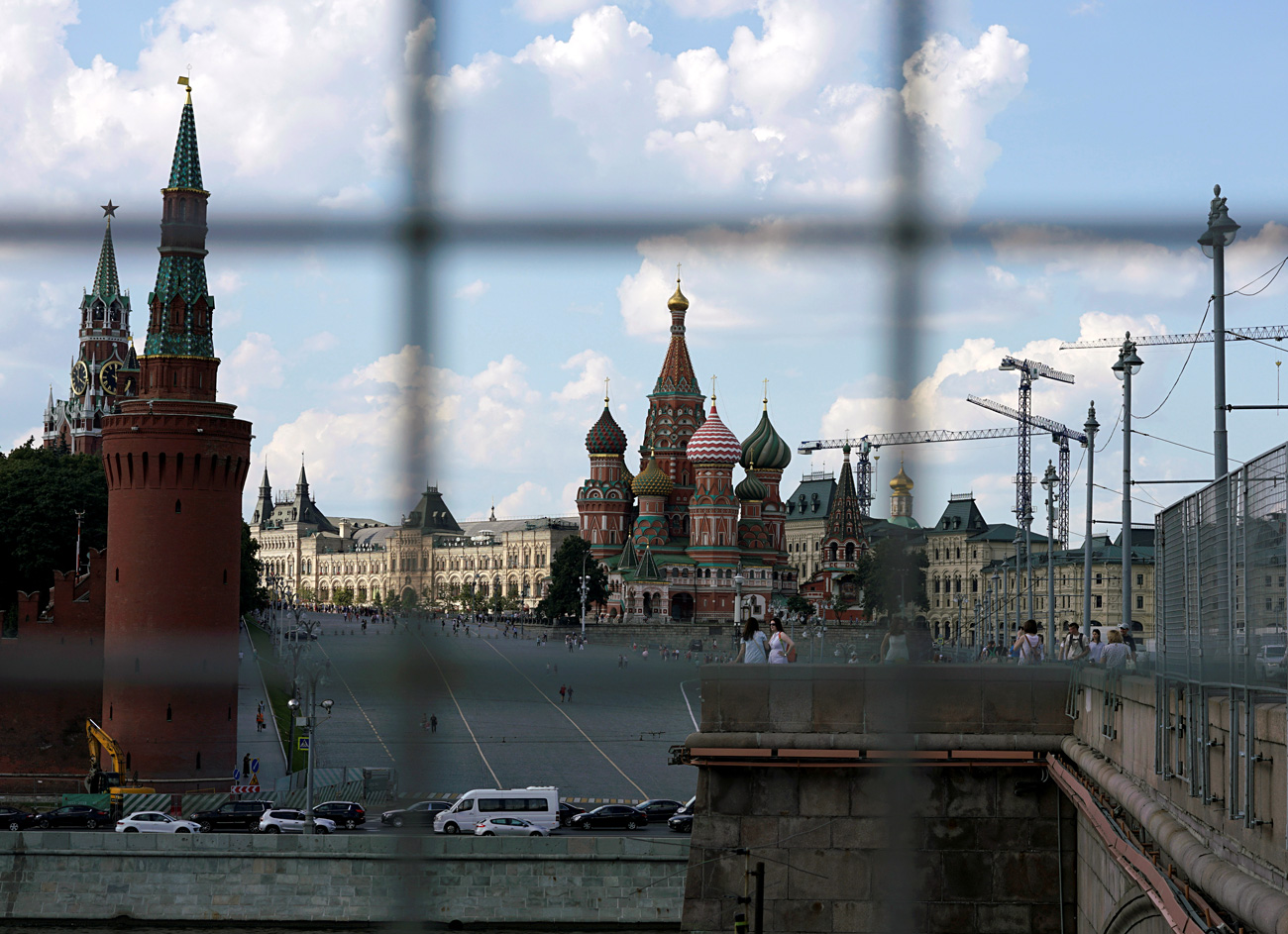A view through a construction fence shows the Kremlin towers and St. Basil's Cathedral on a hot summer day in central Moscow, Russia, July 1, 2016.