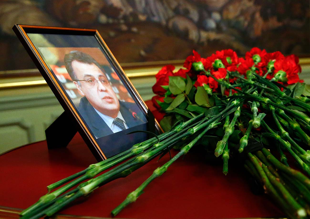 Des fleurs devant un portrait d'Andreï Karlov.