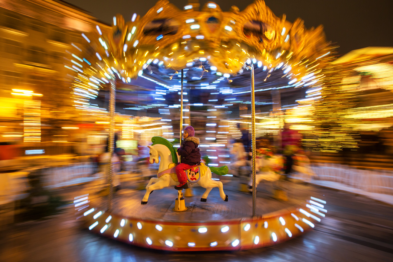 MOSCOW, RUSSIA - DECEMBER 31, 2016: People on a merry-go-round in Tverskaya Street in central Moscow during the Puteshestviye v Rozhdestvo (Journey to Christmas) Festival. 