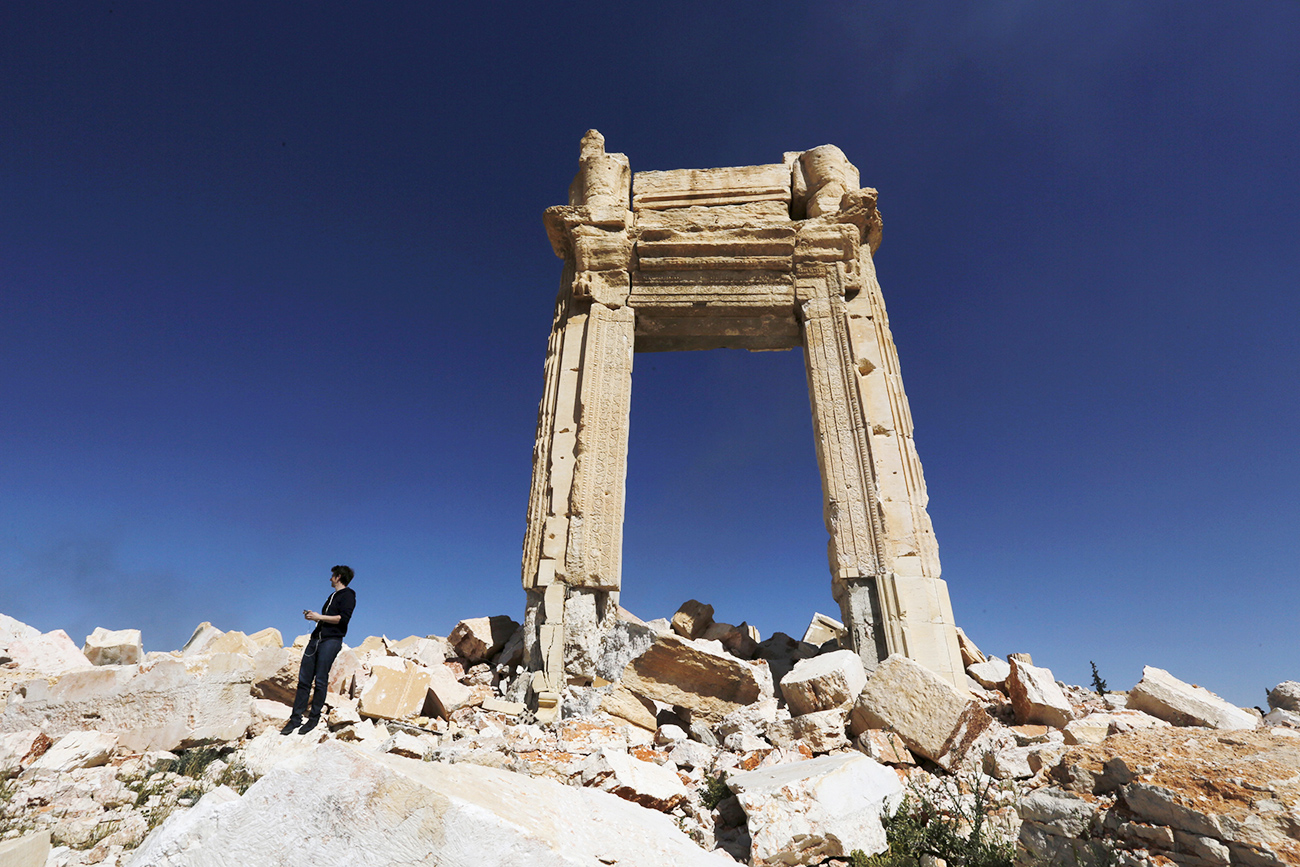 A journalist stands at the remains of the Temple of Bel in the historic city of Palmyra, Syria.