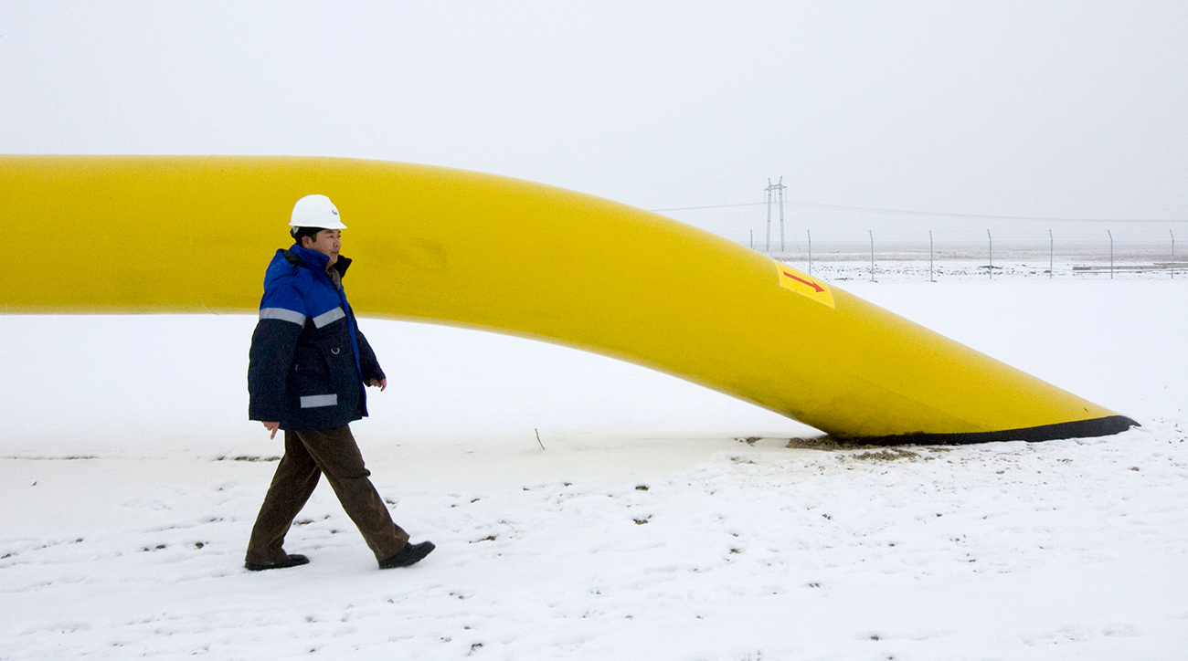A Chinese worker of Asia Gas Pipeline (AGP) walks along the pipe of the Kazakh stretch of the new Turkmenistan-China pipeline at Otar gas station.